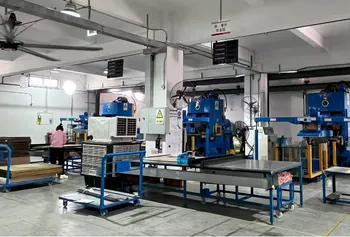 Presses and forming equipment on the workshop floor with an operator at a workstation