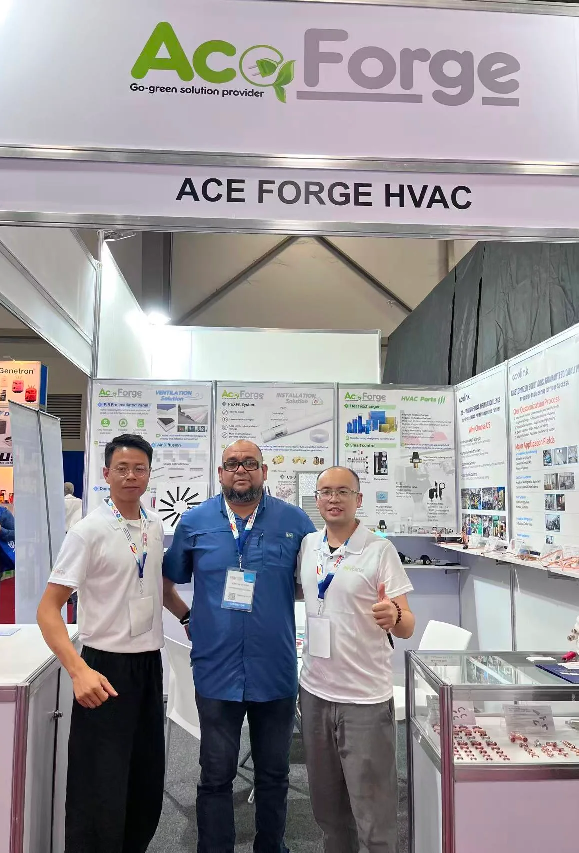 Two ACE FORGE staff and a visiting distributor in front of the ACE FORGE HVAC booth header